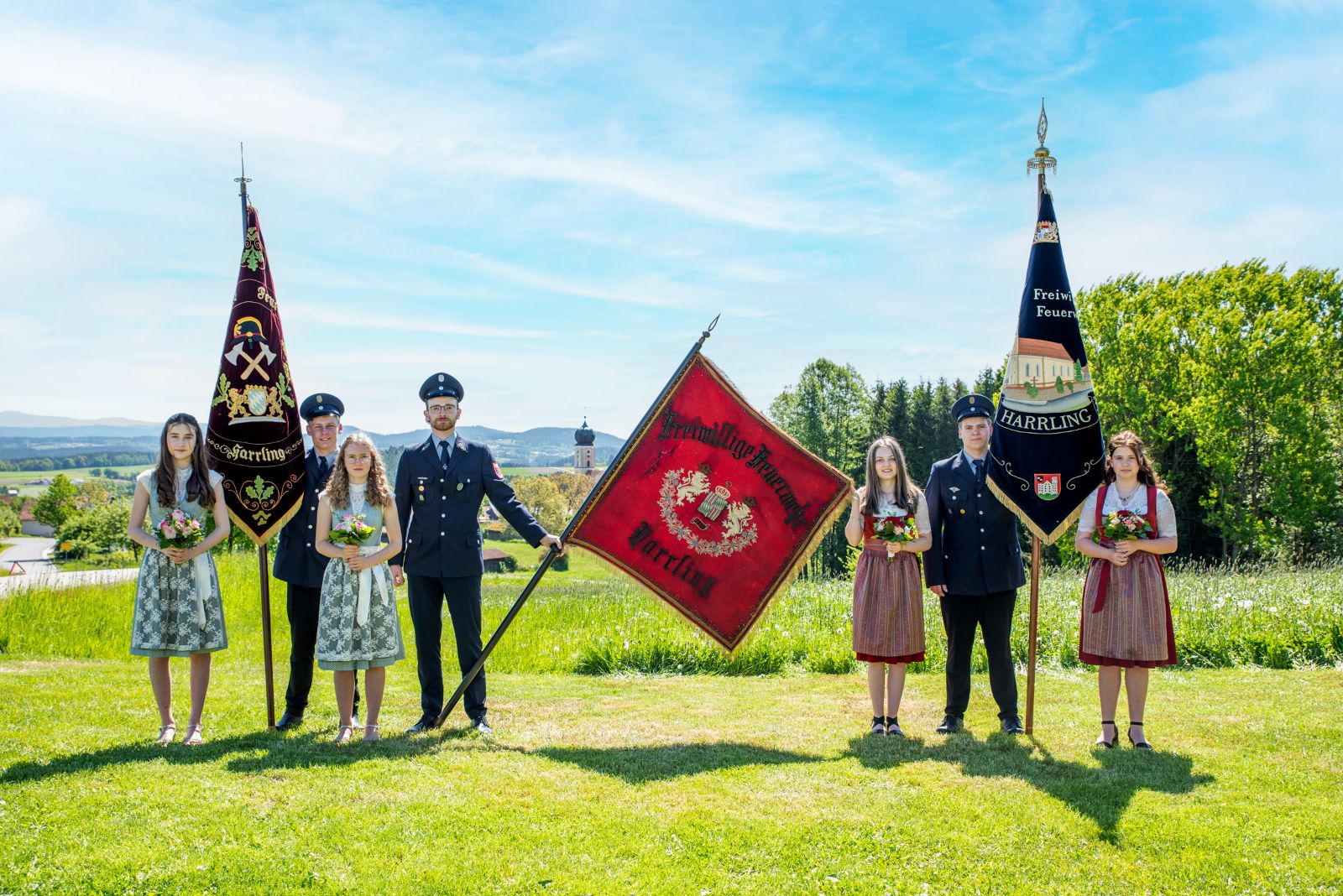 Die drei Fahnen der Freiwilligen Feuerwehr Harrling mit Fahnenbegleitung